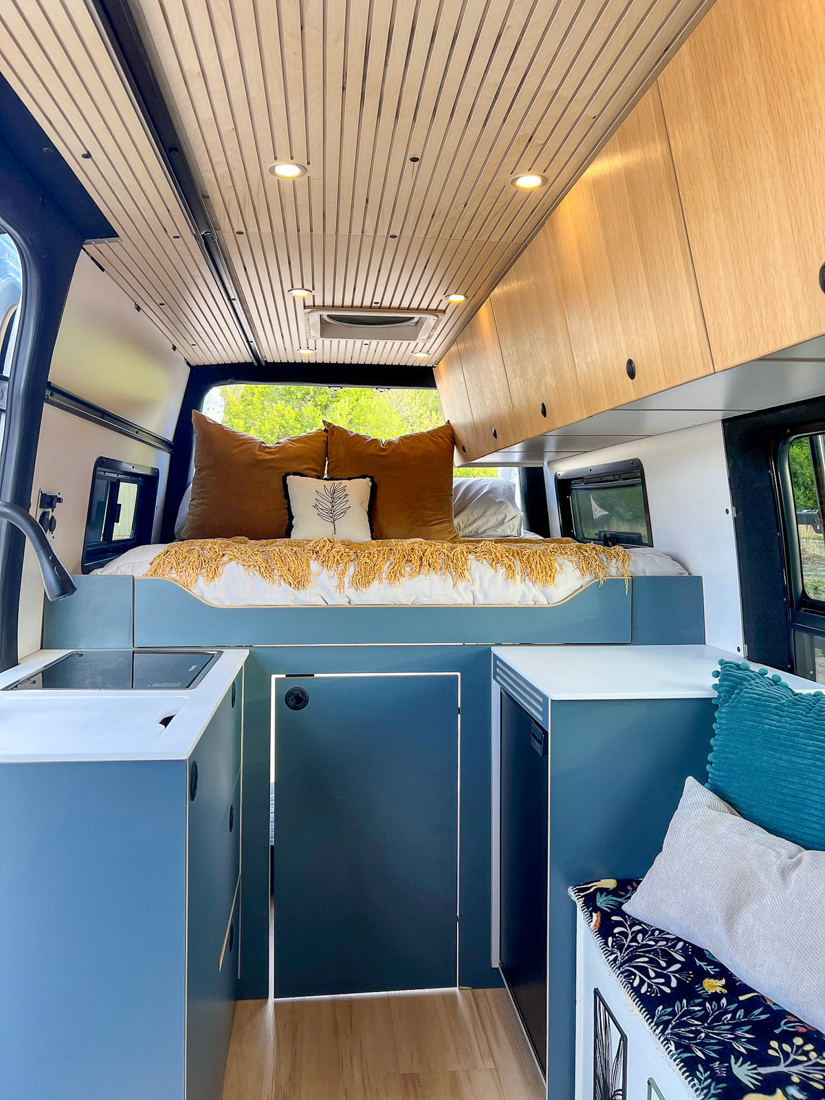 Mars interior with the rear bed, blue cabinetry and wood upper cabinets