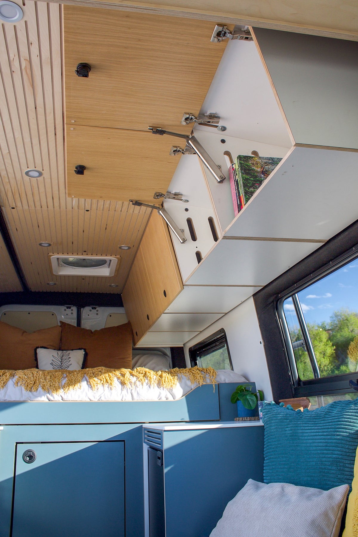 Angled wood upper cabinets running the length of the Mars van